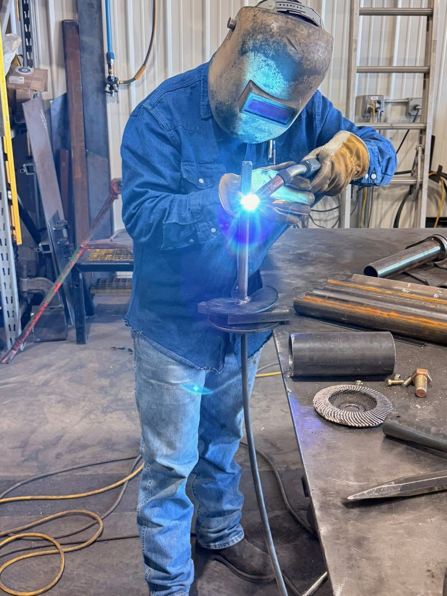 An Iron Marine welder welding the anchor's auger base in the shop