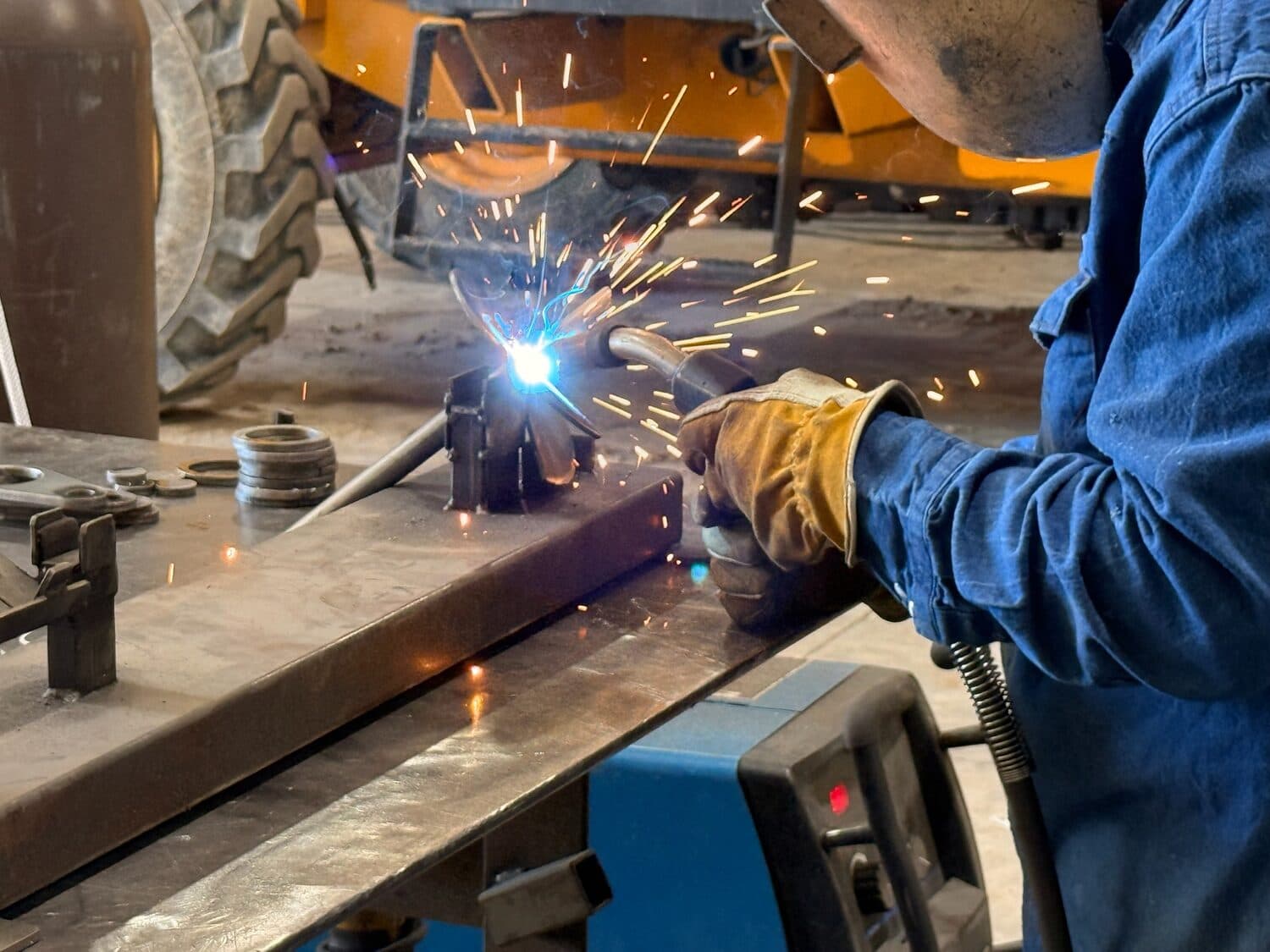 An Iron Marine welder MIG-welding an anchor component in the shop